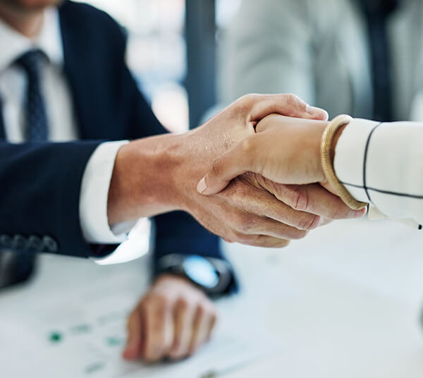 two people shaking hands, it's mostly their hands and wrists in focus